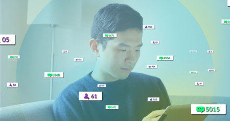 Reviewing tablet Asian man sitting on sofa under floor lamp in living room, with digital overlays. Technology, digital, modern, connectivity, relaxation, home, innovationの写真素材