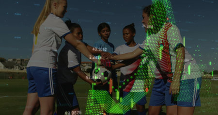 Huddling soccer players wearing jerseys stacking hands over ball on grass field, with chart overlay....