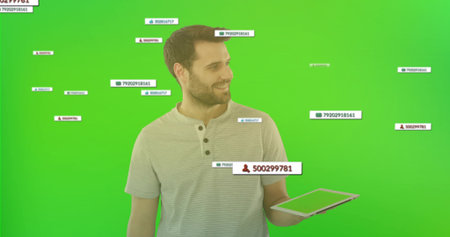 Male wearing henley shirt displaying floating overlays with icons on tablet in green backdrop set. Technology, communication, digital, innovation, modern, ui, interfaceの写真素材
