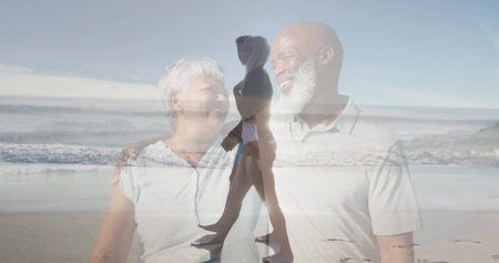 Mature couple laughing and looking at each other on beach, overlaying walking woman holding device. Romance, beachscape, serenity, connection, outdoor, companionship, tranquilityの写真素材