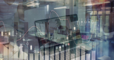 Displaying laptop showing executive in suit pointing during meeting in office, with chart overlay....
