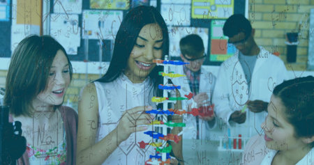 Snapping red connector student in sleeveless white top assembling double helix model in school lab. Educational, teamwork, innovation, scientific, collaborative, vibrant, youthfulの写真素材