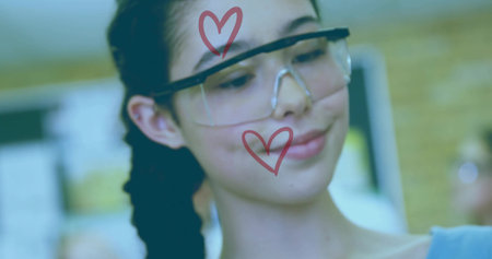 Teenage student testing circuit in school lab, wearing clear safety goggles with red heart symbols. Educational, youthful, innovative, modern, stem, engagement, creativeの写真素材