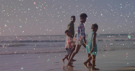 Walking family wearing summer clothes along wet sand shoreline at calm ocean edge, light particles....