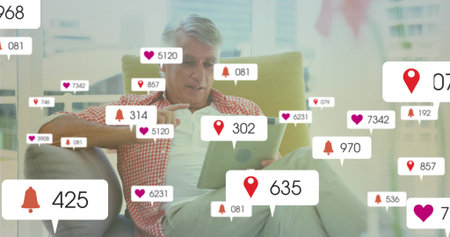 Interacting senior man tapping tablet in armchair in living room, with notification overlays....