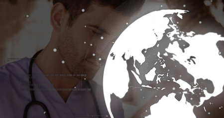 Standing doctor in hospital hallway wearing scrubs and stethoscope, with globe overlay, copy space. Healthcare, telemedicine, digital health, medical technology, global health, professional, innovationの写真素材