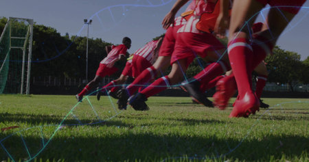 Sprinting seven athletes wearing red kits and cleats across soccer field toward goal, with overlays....