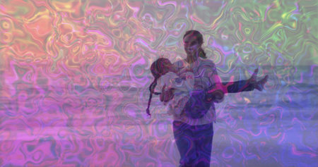 Walking mother carrying daughter along sandy beach shore, with gentle waves and pastel sunset sky. Motherhood, family, ocean, landscape, serenity, bonding, affectionateの写真素材