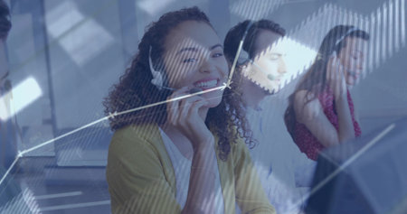 Smiling agent wearing yellow cardigan speaking on headset at office, with monitors, copy space....