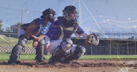 Crouching catchers holding mitts at baseball home plate, with helmets and chest protectors....
