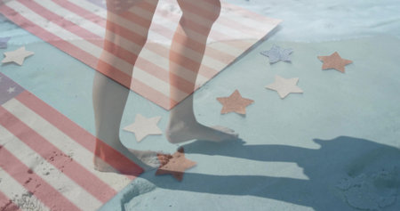 Stepping bare feet on sandy painted surface at beach edge, with striped towel, star-shaped cutouts. Barefoot, sand, coastal, leisure, vibrant, playful, outdoorの写真素材