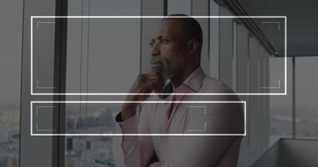 Standing pink-shirted businessman gazing through window panels in modern office, with city skyline. Professional, productivity, architecture, leadership, vision, sleek, corporateの写真素材