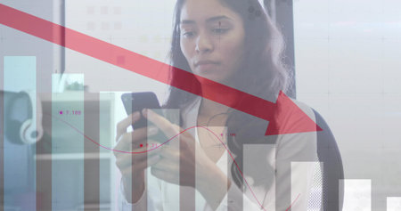 Analyzing woman wearing light blazer viewing downward arrow graph at office desk, with smartphone. Technology, data, analytics, business, corporate, professional, minimalistの写真素材