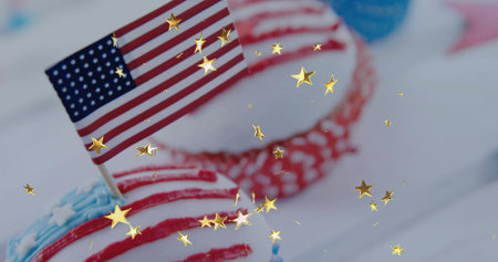 Cupcake sitting on white tabletop, with American flag pick, polka-dot cupcake and gold confetti. Festive, celebration, decorative, cheerful, patriotic, vibrant, eleganceの写真素材