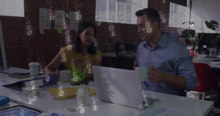 Collaborating on project documents coworkers holding coffee mugs at modern office desk, with laptop....