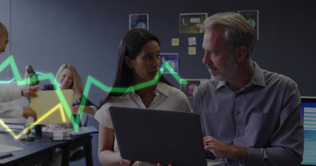 Woman in business attire and man discussing data on laptop at office area, with sticky notes. Collaboration, teamwork, data analysis, business meeting, modern workspace, professional environment, digital technologyの写真素材