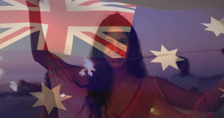 Celebrating friends in coverup holding sparklers on sandy shore at dusk, Australian flag overlay. Festivity, camaraderie, twilight, beachlife, outdoor, celebration, vibrantの写真素材