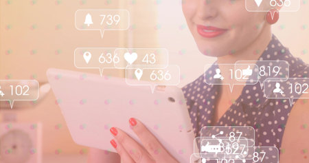 Smiling woman in navy blouse holding tablet beside desk clock, with floating media notifications. Technology, digital, communication, lifestyle, modern, business, vibrantの写真素材