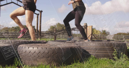 Performing agility drill, workout partners in athletic wear stepping across tires on grassy field. Fitness, outdoor, athletic, training, teamwork, motivation, staminaの写真素材