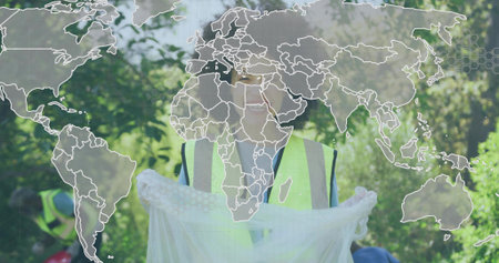 Collecting volunteer holding white bag in wooded park, wearing neon vests gloves, with map overlay. Community, environmental, sustainability, conservation, teamwork, outdoor, activismの写真素材