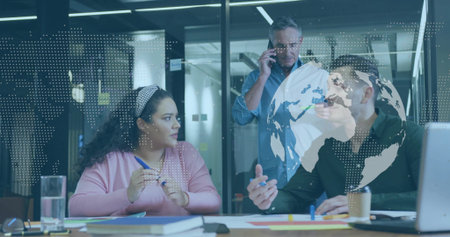 Three professionals wearing office wear discussing project plan in meeting room, with laptop notes....