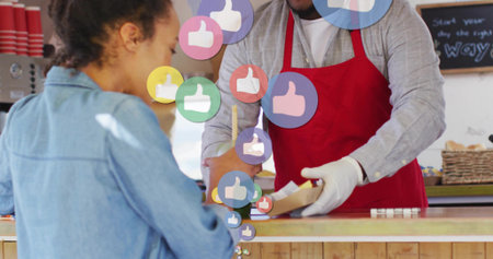 Receiving mid adult woman in denim jacket accepting paper tray inside coffee shop, digital icons. CafÃ©, service, hospitality, modern, vibrant, social, customerの写真素材