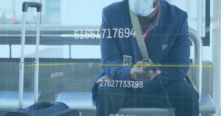 Checking smartphone man wearing suit and mask sitting at airport with suitcase and bag amid overlay. Travel, transit, business, technology, modern, connectivity, professionalismの写真素材