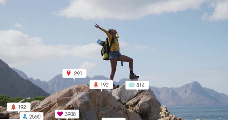 Raising arms overhead hiker standing on coastal rock, with backpack, hiking boots and overlay icons. Adventure, exploration, outdoor, scenic, freedom, travel, natureの写真素材