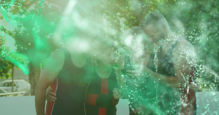 Sharing smartphone, four friends in sportswear leaning on sunlit patio, with white deck railing. Outdoors, camaraderie, leisure, modern, relaxation, community, lifestyleの写真素材