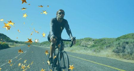 Riding male cyclist pedaling on road bicycle along rural highway. Adventure, fitness, movement,...