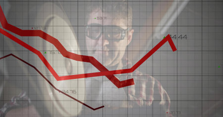 Mature analyst wearing glasses and plaid shirt analyzing charts in office, with red line graphs. Financial, data, analytics, professional, modern, enterprise, corporateの写真素材