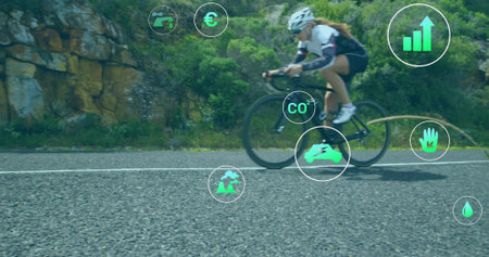 Female cyclist wearing helmet, cycling shoes riding road bike in mountain pass, with data icons. Adventure, sustainability, technology, fitness, outdoor, eco-friendly, data visualizationの写真素材