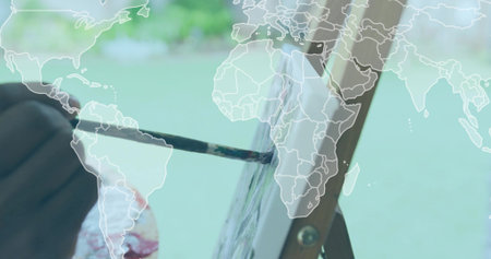 Pressing brush, artist applying paint onto canvas on easel in garden, world map overlay, copy space. Creativity, outdoors, craftsmanship, landscape, inspiration, environmental, fine artsの写真素材