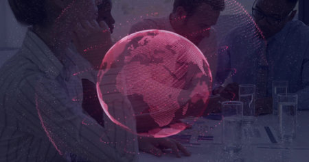 Projecting red holographic globe above table, business-casual colleagues reviewing reports....