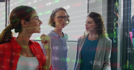 Discussing professional women gesturing at glass board in modern office, with stock data overlay. Businesswomen, collaboration, innovation, finance, consulting, modernity, teamworkの写真素材