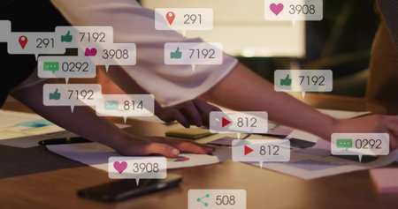 Leaning business-clad colleagues reviewing charts, graphs at wooden table, with social media icons. Collaboration, teamwork, analytics, data, professional, meeting, seniorの写真素材