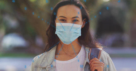 Student standing in park wearing surgical mask and denim jacket, with backpack and numeric overlay. Outdoor, casual, futuristic, technology, nature, wellness, healthの写真素材