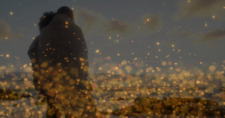 Hugging couple standing wrapped in blanket on beach at sunset, with ocean waves and golden bokeh. Romance, serenity, intimacy, coastal, dusk, glow, leisureの写真素材