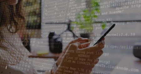 Holding smartphone, female coder scanning ports at desk with monitor and coffee mug, copy space. Technology, cybersecurity, innovation, workspace, digital, communication, modernの写真素材