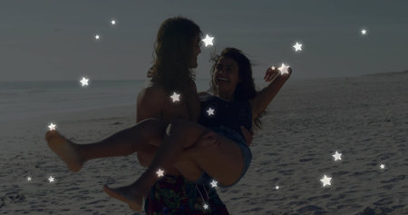 Shirtless man carrying woman in crop top and shorts on sandy beach, with faint star overlay. Romance, adventure, carefree, leisure, scenic, affectionate, harmonyの写真素材