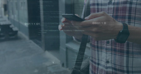 Holding smartphone plaid-shirted man scanning binary overlay on sidewalk by facade, copy space. Technology, urban, modern, innovation, communication, streetwear, futuristicの写真素材