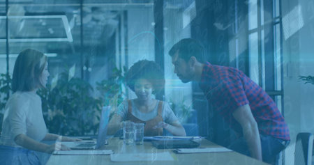 Collaborating three colleagues reviewing data charts in glass meeting room, with laptops papers. Teamwork, innovation, productivity, brainstorming, corporate, modern, digitalの写真素材