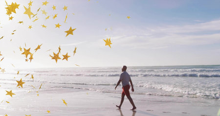 Walking mature man in white T-shirt and red shorts along wet shoreline. Seaside, relaxation, minimalist, wellness, leisure, outdoor, reflectiveの写真素材