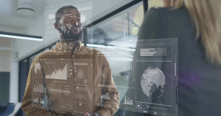 Male professional wearing brown shirt examining data overlays on glass partition in office. Technology, collaboration, data visualization, futuristic, corporate, innovation, communicationの写真素材
