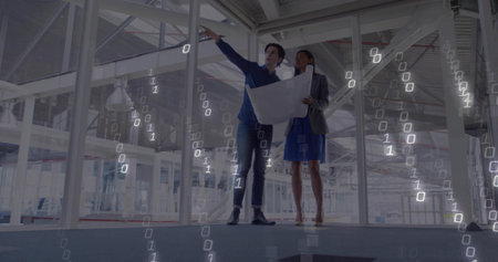 Two professionals wearing formal attire holding blueprint and pointing in unfinished building. Architectural, industrial, blueprint, construction, structural, planning, engineeringの写真素材