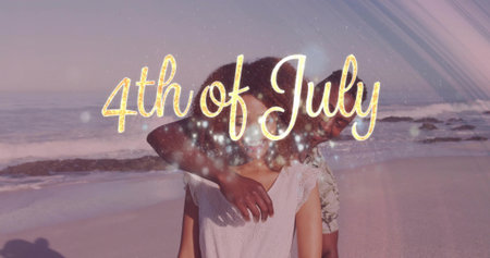 Embracing couple wearing casual tops on sunset beach. Romance, outdoors, celebration, serenity,...