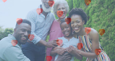 Smiling multi-generational family members standing in backyard, featuring red heart overlays. Family, togetherness, celebration, affection, generational, outdoor, vibrantの写真素材