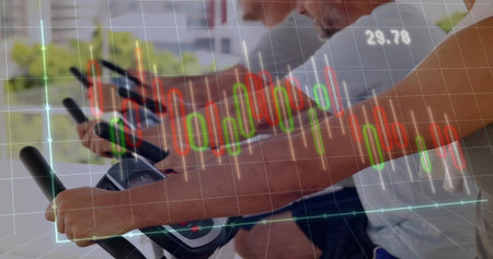 Spinning three men pedaling on spin bikes in spin studio by windows with financial chart overlay. Fitness, teamwork, vitality, innovation, health, motivation, modernの写真素材