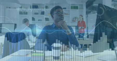 Focusing data analyst wearing blue shirt examining desktop graphs on monitors at open plan office....