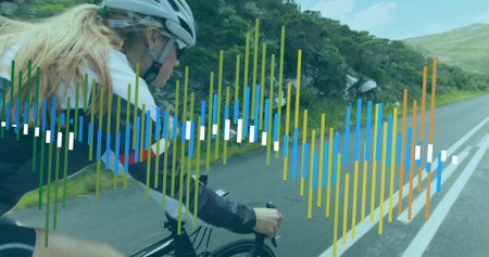 Cyclist pedaling road bike wearing helmet with computer along hilly road, copy space. Outdoor,...
